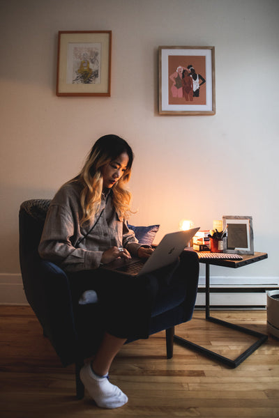 Une personne assise à la maison avec son ordinateur portable