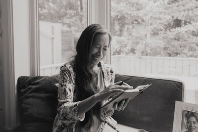 Looking back at notes, smiling